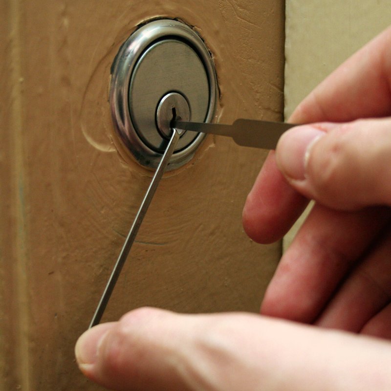 close up of lock picking to gain entry using locksmith picking tools